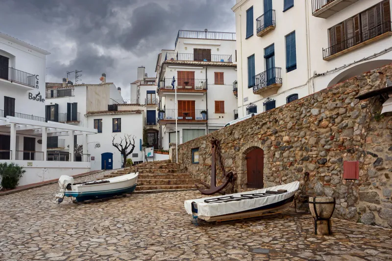 Casas blancas de baja altura en el litoral de Alcossebre, con barcas varadas en la orilla del Mediterráneo