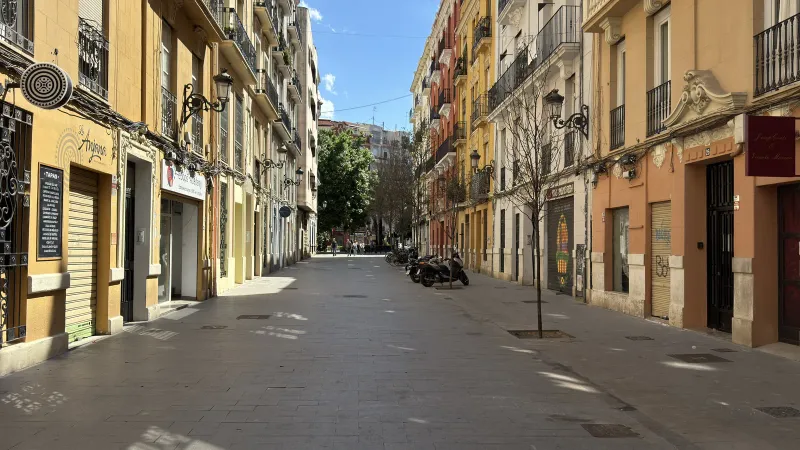 Calle peatonal de Ruzafa con fachadas de colores y comercios, sin tráfico