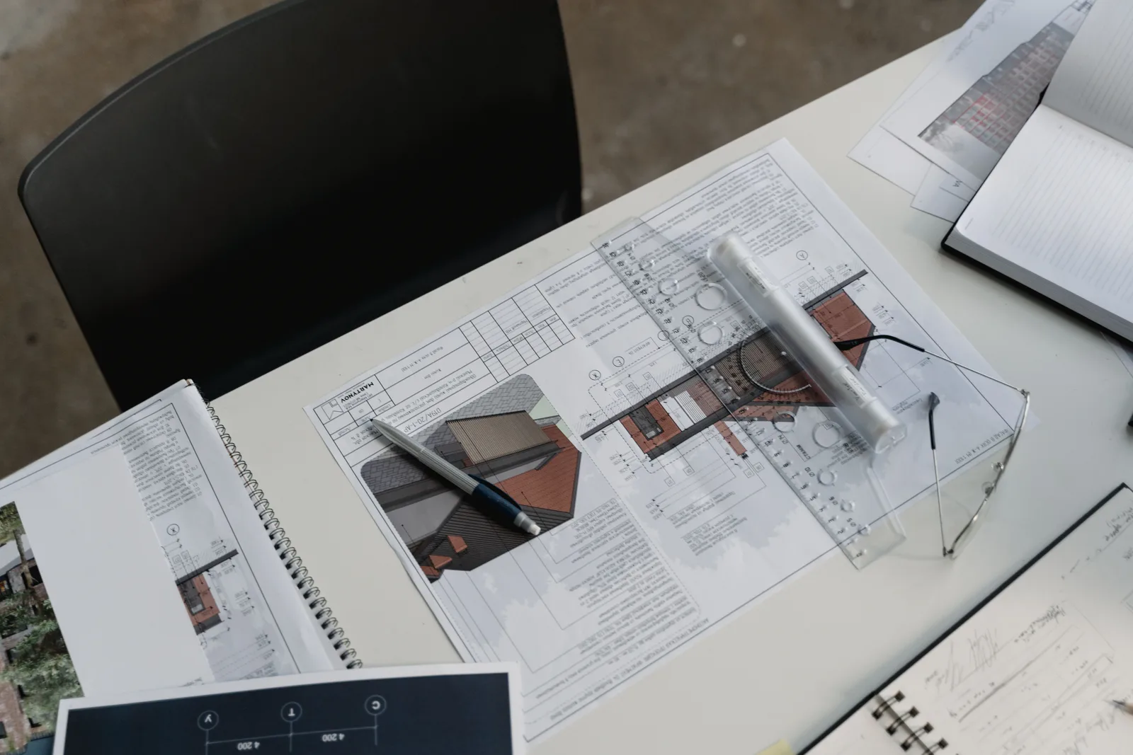 Planos y documentación de una reforma sobre una mesa, representando el trámite de obras sin declaración responsable