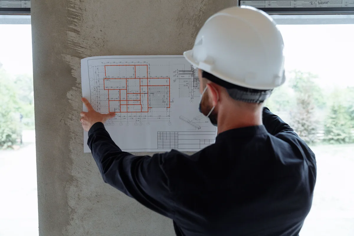 Técnico competente revisando documentación técnica de un edificio para redactar el IEEV.CV