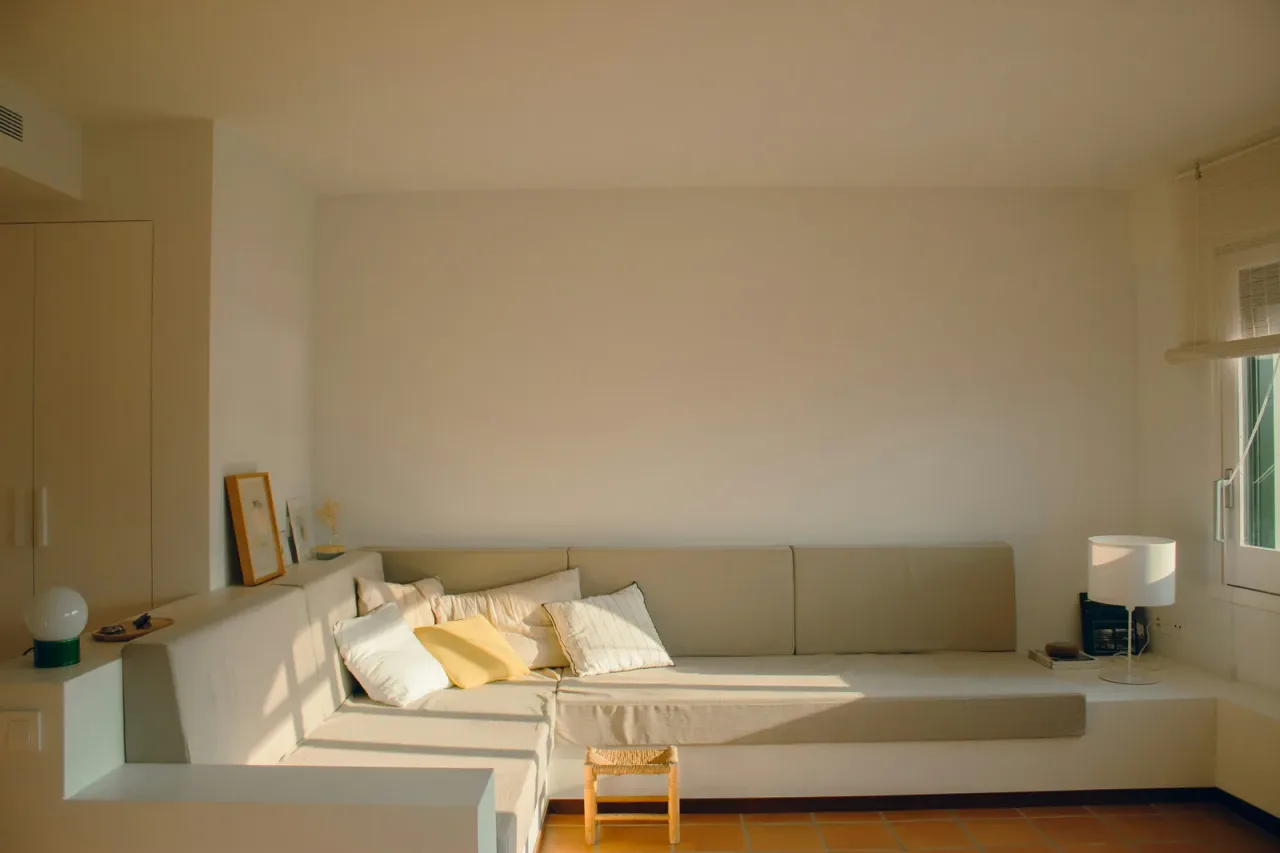 Interior de vivienda en reforma con tabique abierto que muestra instalaciones antiguas ocultas tras el revestimiento