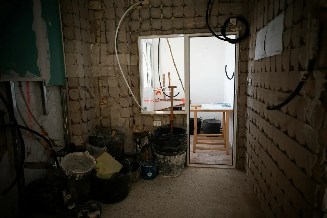 Varios presupuestos de obra impresos junto a un plano de mediciones sobre una mesa para comparar ofertas de constructoras
