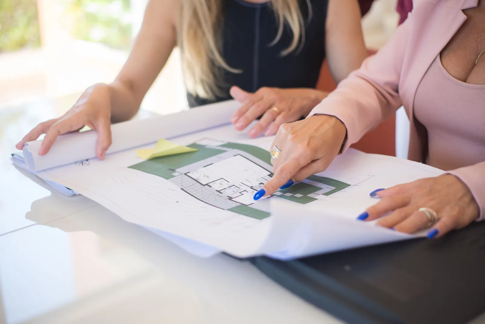 Equipo de arquitectura revisando planos de una vivienda unifamiliar con jardín